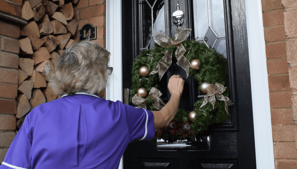 A Rennie Grove Peace nurse knocking on a festive door