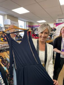 MP Daisy Cooper showing a dress in the Rennie Grove Peace charity shop, St Albans