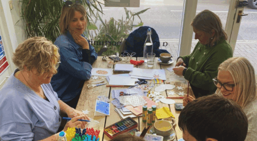 people sitting round a table doing arts and crafts