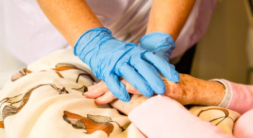 nurse holding patients hand