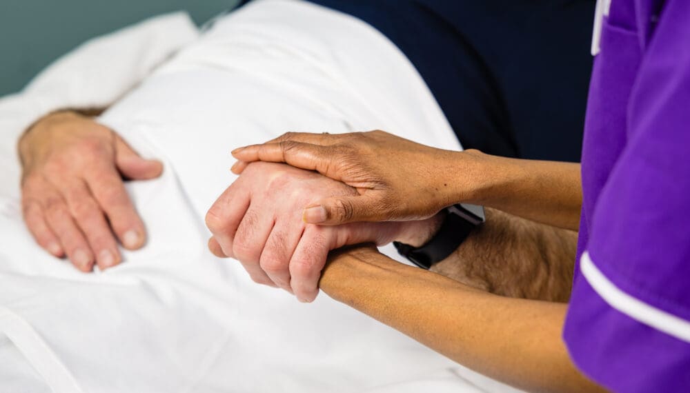 nurse holding patients hand