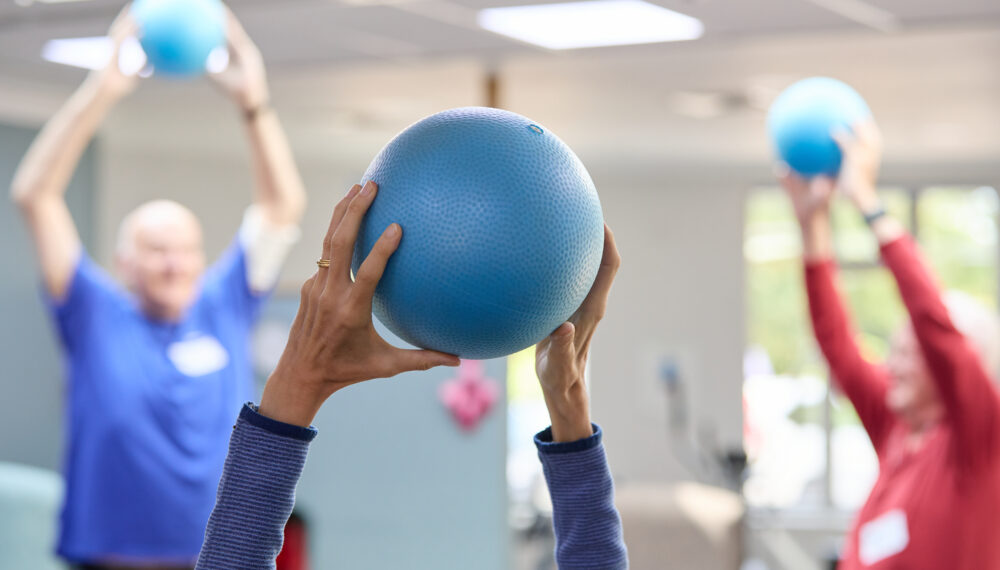 people holding a ball for exercise class