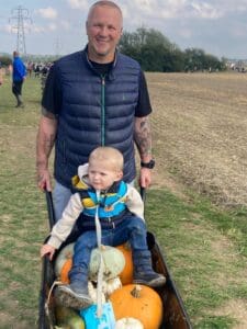 Man and son with a wheelbarrow and pumpkins