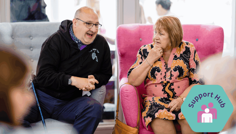 two people sit and chatting with support hub logo