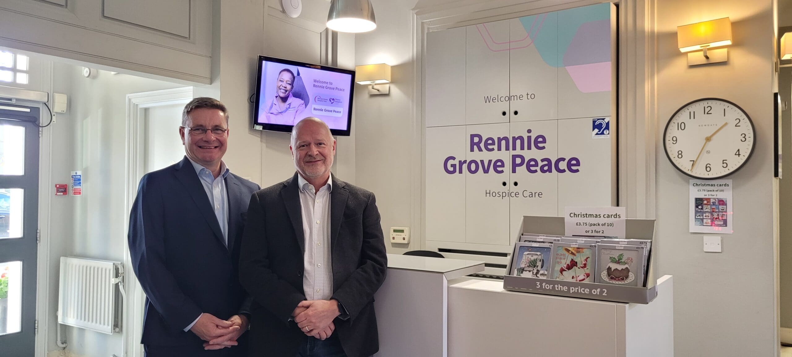 Two men in front of the Rennie Grove Peace Hospice sign