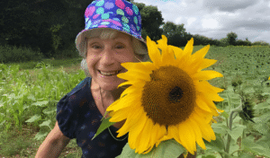Joan smiling with a huge sunflower