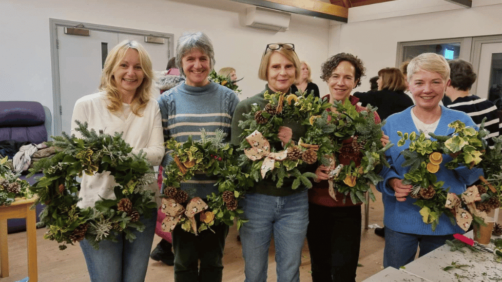 a group of ladies holding their wreath creations